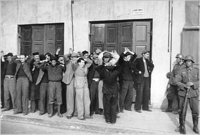 German soldiers round-up a group of Jewish men on a street in Czestochowa